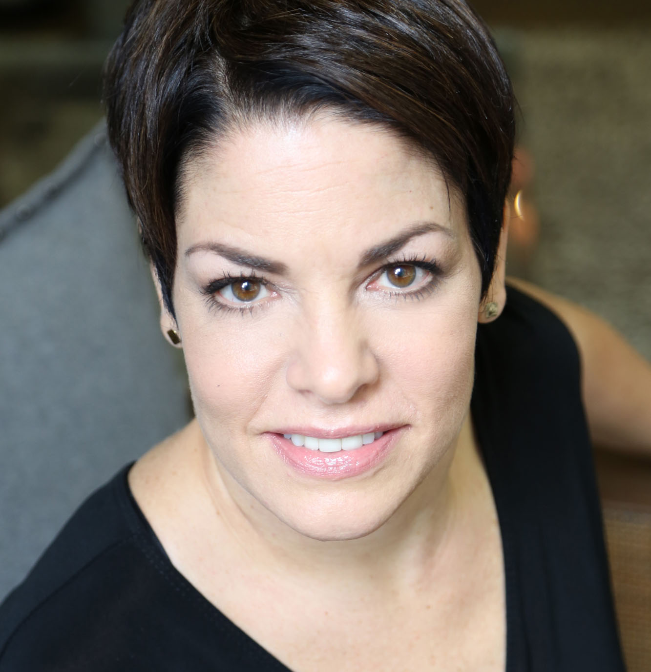 Woman with short dark hair looking straightinto the lens.