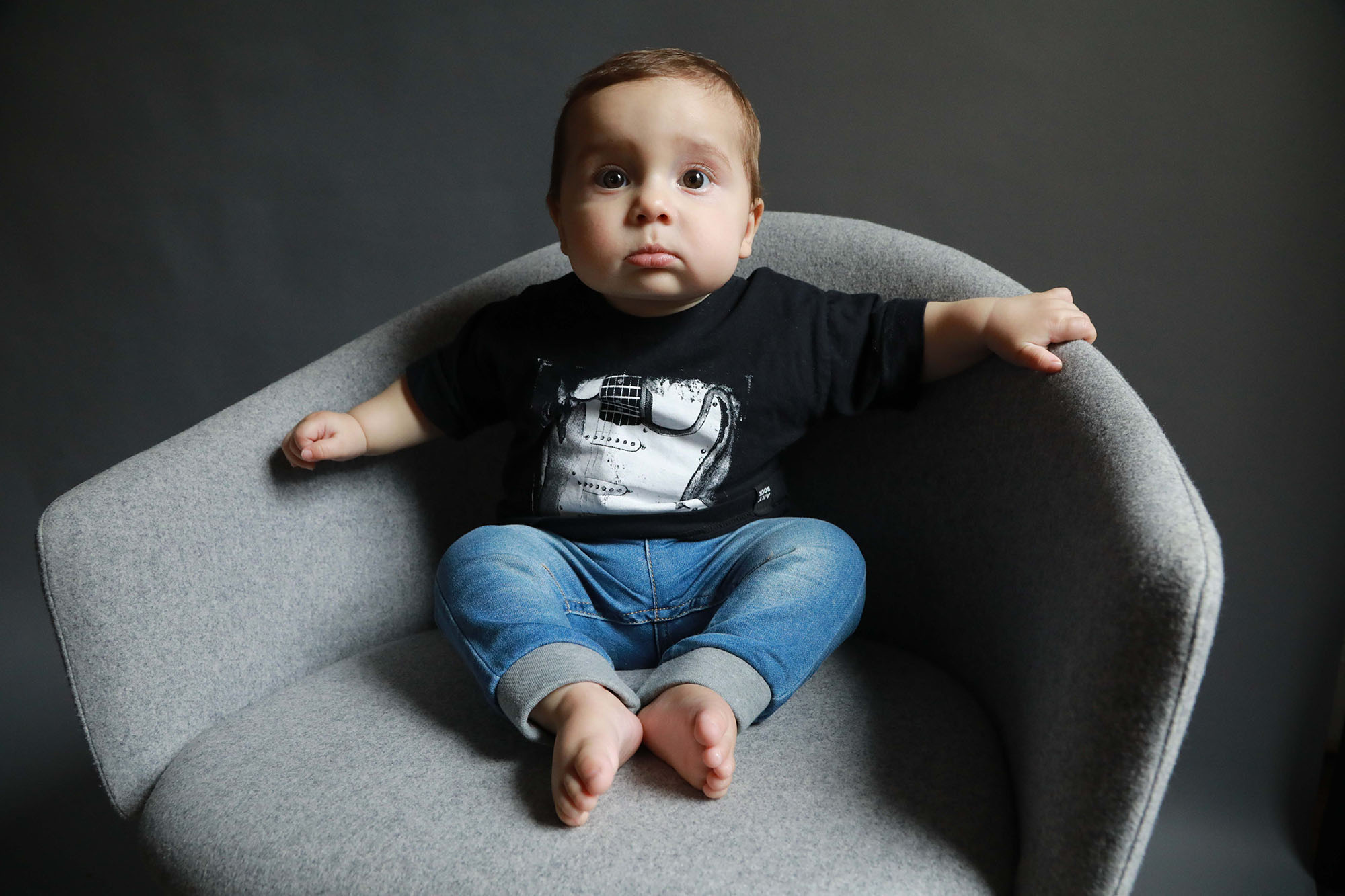 toddler boy with xxy syndrome sitting in a chair and looking into the camera