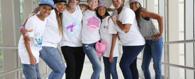 woman with Vitiligo poses with her family in hallway