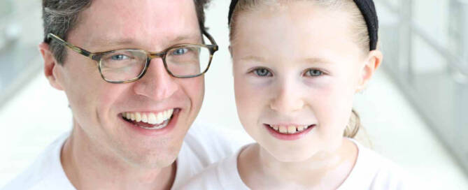 girl with Vitiligo standing next to her dad