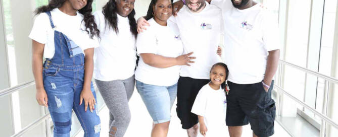 boy with Vitiligo poses with his family in a hallway