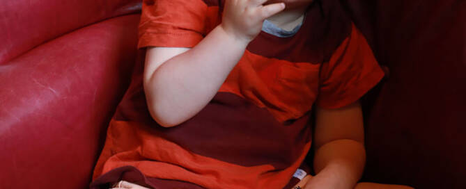 young boy with red glasses looking to the left