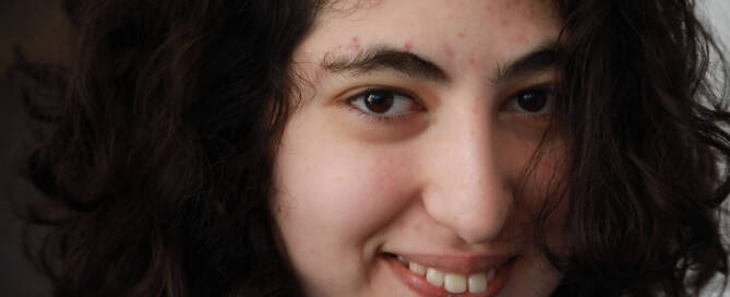 girl with Phelan-McDermid Syndrome looking into the camera and smiling. closeup photo