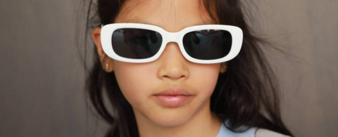 young girl with Phelan-McDermid Syndrome wearing white sunglasses facing the camera