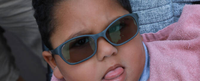 Young girl with grey sunglasses looking into the camera, closeup photo