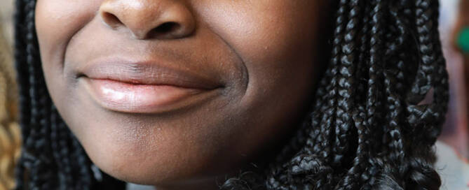 girl with Phelan-McDermid Syndrome looks into the camera and smiles lightly