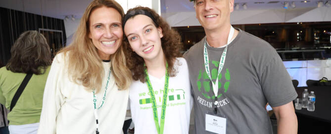 girl with Phelan-McDermid Syndrome hugging both her mother and father for a picture, all smiling