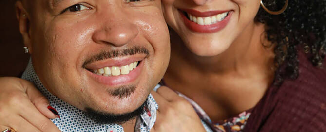 man with xxy syndrome being hugged by his partner. both smiling at the camera