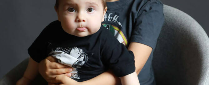 toddler boy with xxy syndrome being held by his older brother. sitting down