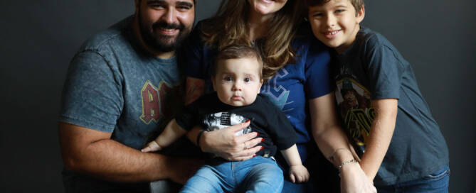 toddler boy with xxy syndrome being held by mother. family photo with father and brother as well