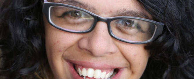 woman with williams syndrome wearing glasses and smiling, closeup photo