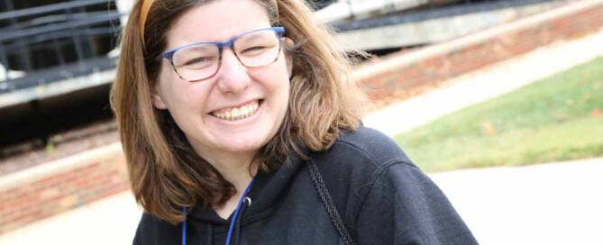 girl with Xeroderma Pigmentosum smiling at the camera, wearing glasses